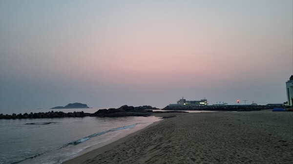 봉포항 회센터 건물 뒤쪽으로 하늘이 점점 환하게 밝아오고 있다. (사진=전수영 기자)